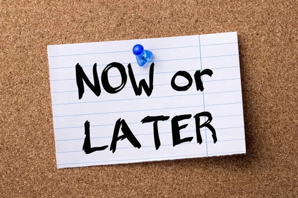 NOW or LATER - teared note paper  pinned on bulletin board