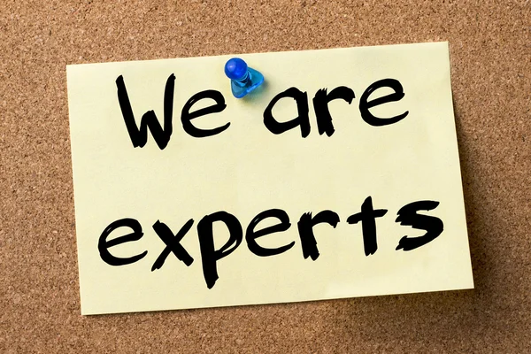 We are experts - adhesive label pinned on bulletin board