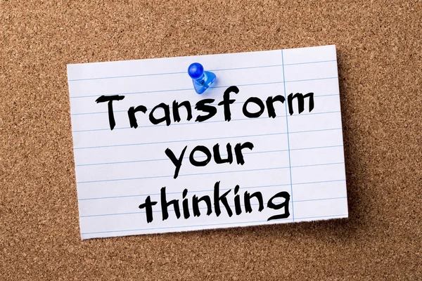 Transform your thinking - teared note paper pinned on bulletin b
