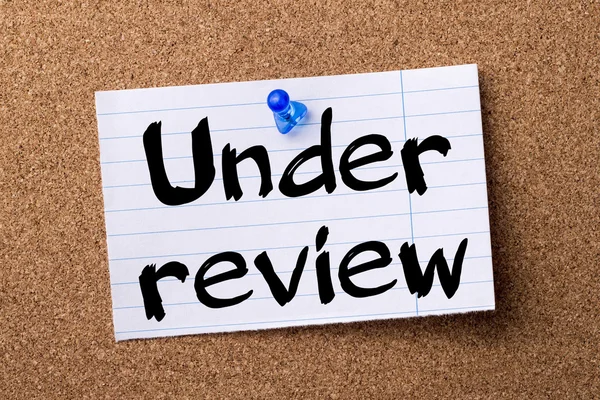Under review - teared note paper pinned on bulletin board