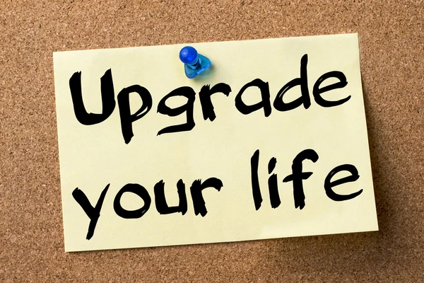 Upgrade your life - adhesive label pinned on bulletin board