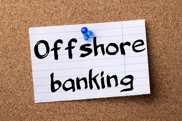Offshore banking - teared note paper pinned on bulletin board