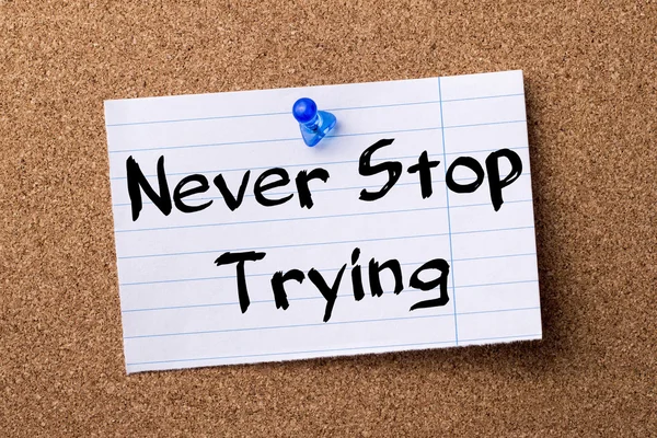 Never Stop Trying - teared note paper pinned on bulletin board