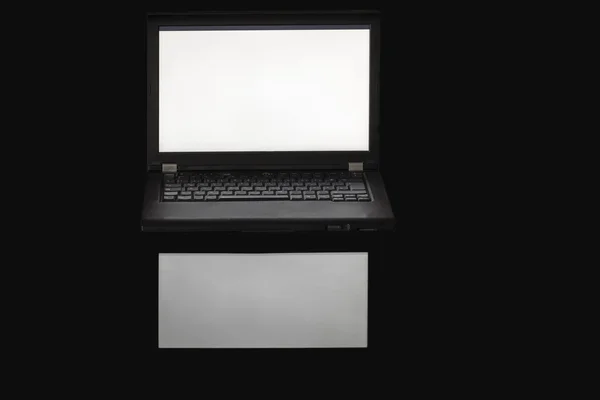 Laptop in the dark with illuminated display