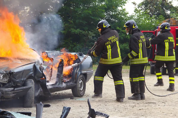Firefighters extinguishing car on fire.