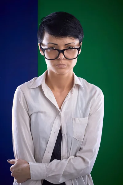 Portrait stylish serious young woman in glasses, bright background