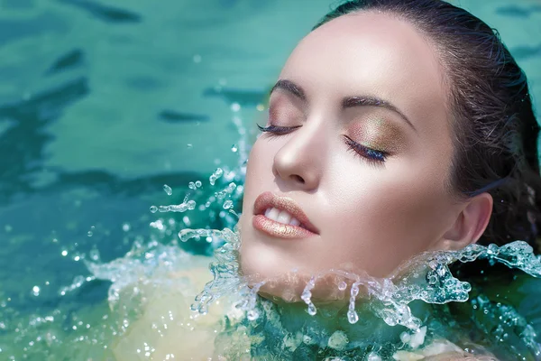 Fashion makeup model in water, splash on face. Moisture wet look.