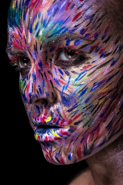 Beautiful fashion woman with bright color face art and body art. Painted lines on face. Creative portrait