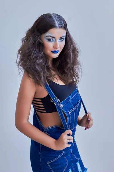 Young model in jeans denimBlue lips, silver eyeshadow, snowy hair.