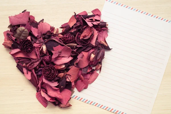 Letter and red heart on wood background