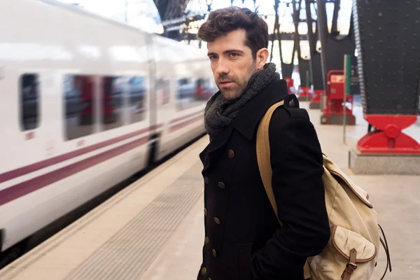 Young man waits for train in station