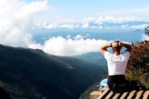 Man relaxes on the edge of the cliff . Plateau \