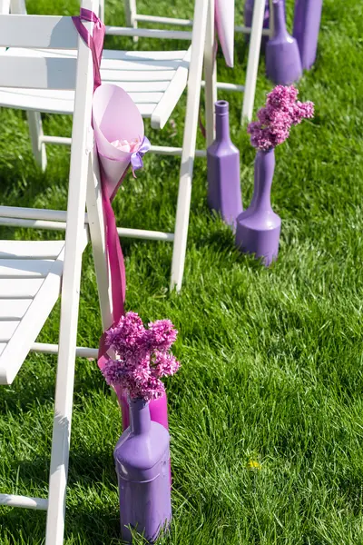 Purple and pink wedding ceremony decorations outdoor in the lawn