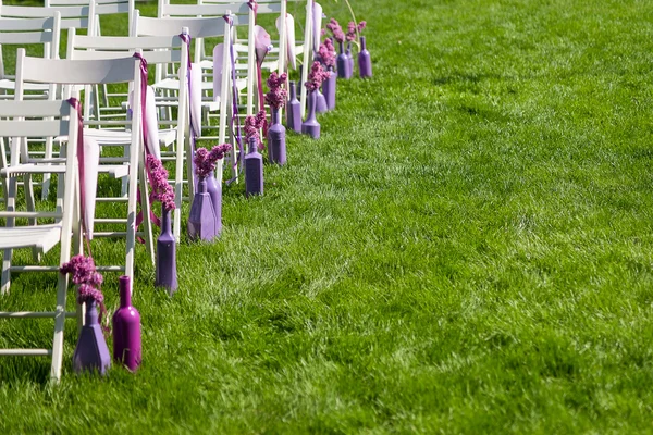 Purple and pink wedding ceremony decorations outdoor in the lawn