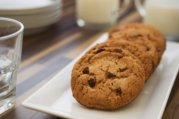 Chocolate chip cookies and milk on dark wood table