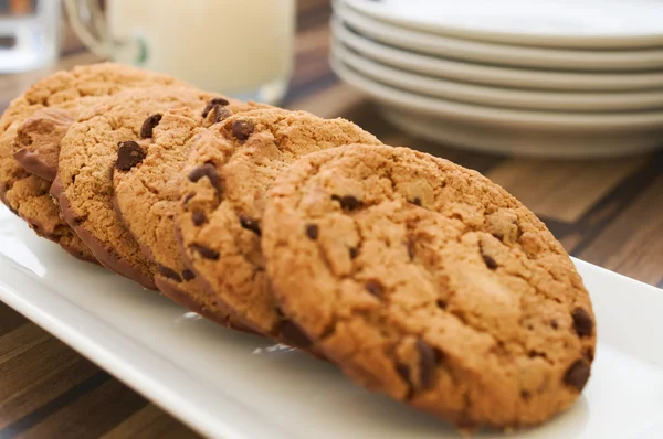 Chocolate chip cookies and milk on dark wood table