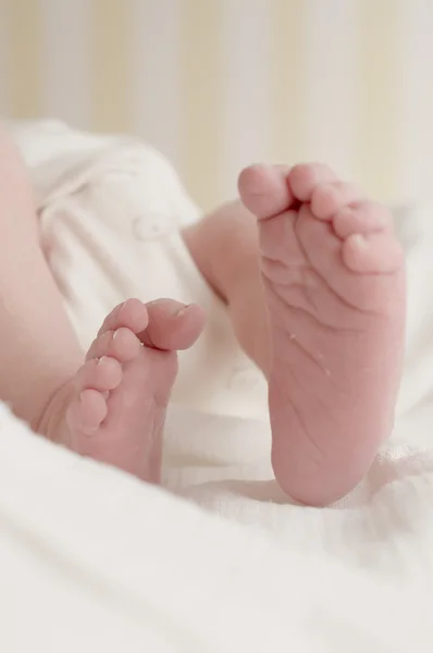 Newborn baby feet on white cloth diaper