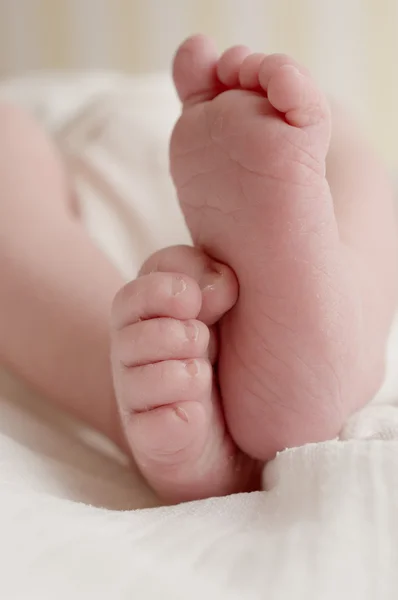 Newborn baby feet on white cloth diaper