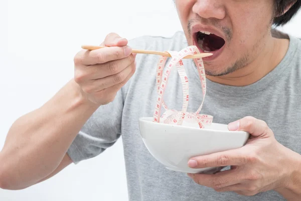 Asian man eating waist measure