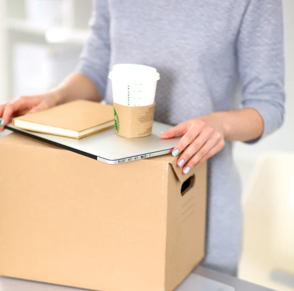 Happy team of businesspeople moving office, packing boxes, smiling