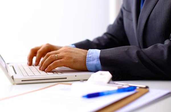 Unrecognizable man using a modern portable computer on an outdoor table, street on background