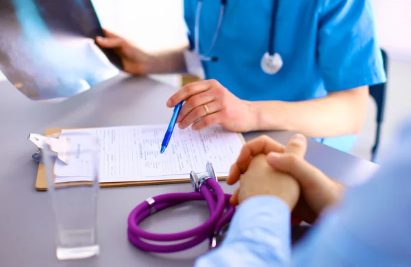 Doctor with stethoscope on the patients admission at the table