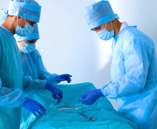 Team of surgeon in uniform perform operation on a patient at cardiac surgery clinic