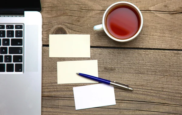 Blank business cards with pen and tea cup on wooden office table