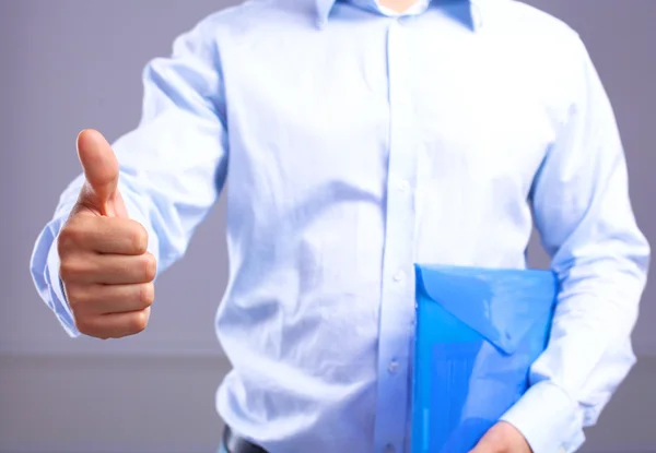 Businessman with papers holds out his hand for a handshake