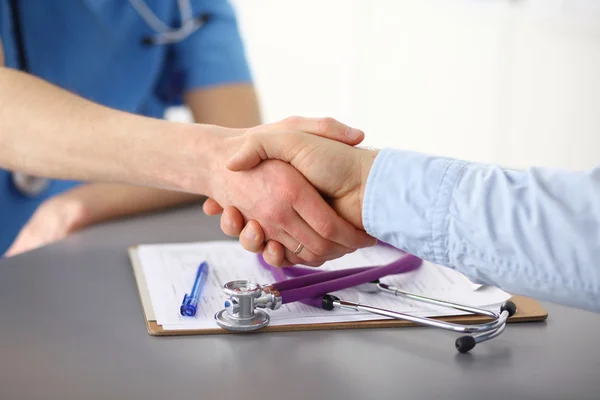 Doctor shakes hands with a patient