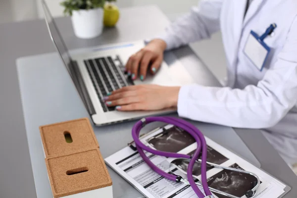 Young woman doctor Close-up works at the computer