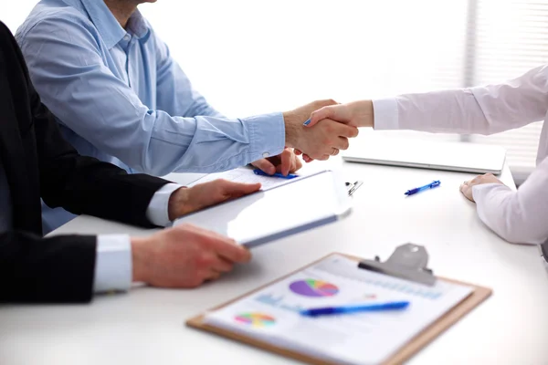 Business people handshake, sitting at the table