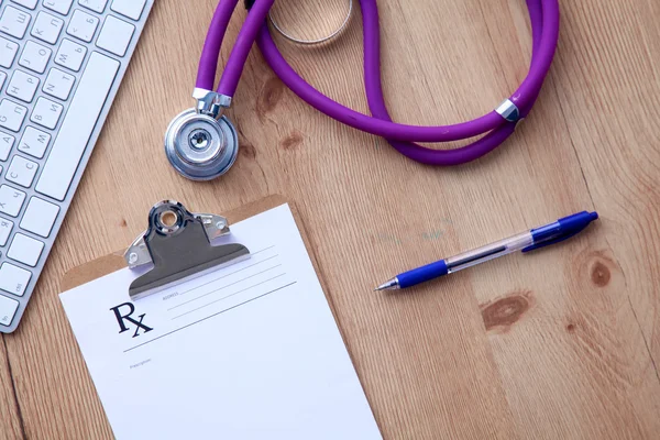 A medical stethoscope near a laptop on a wooden table, on white