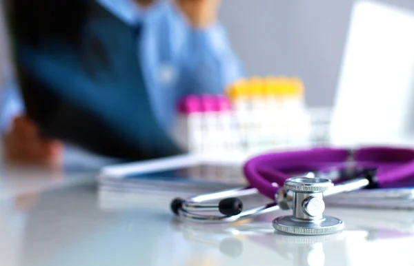 Medical doctor sitting at table and looking patients roentgen