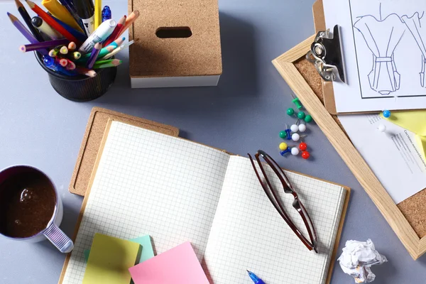 Mix of office supplies and gadgets on a wooden desk background. View from above