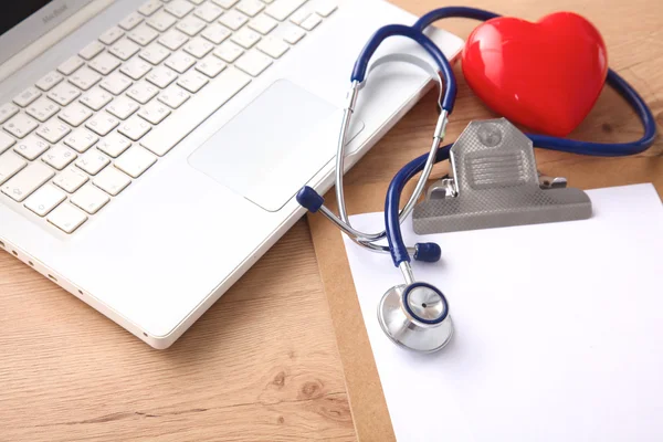 A medical stethoscope near a laptop on a wooden table, on white