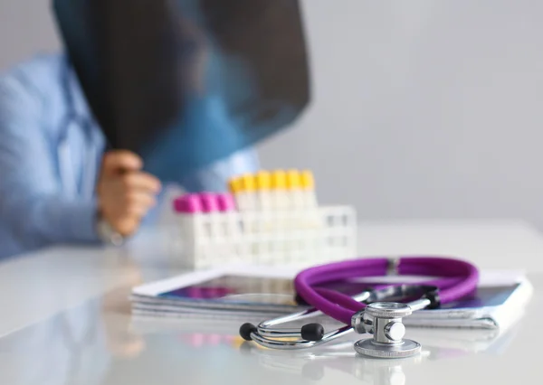 Medical doctor sitting at table and looking patients roentgen