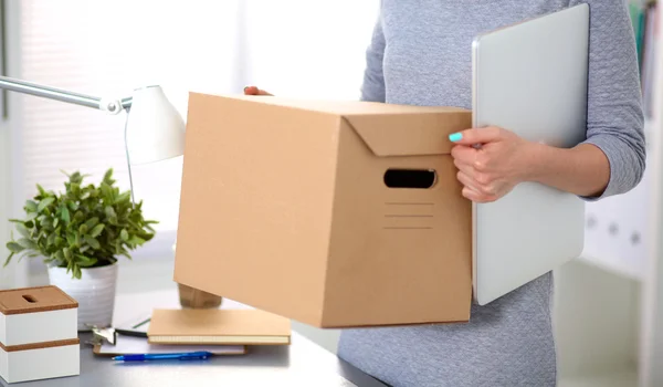 Happy team of businesspeople moving office, packing boxes, smiling