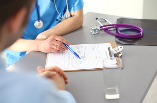 Close up of patient and doctor taking notes