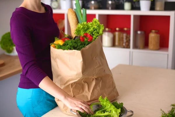 Healthy positive happy woman holding a paper shopping bag full of fruit and vegetables