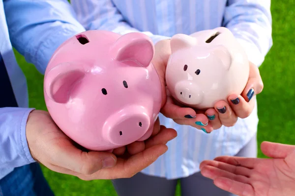 Group of business people saving money on the piggy bank