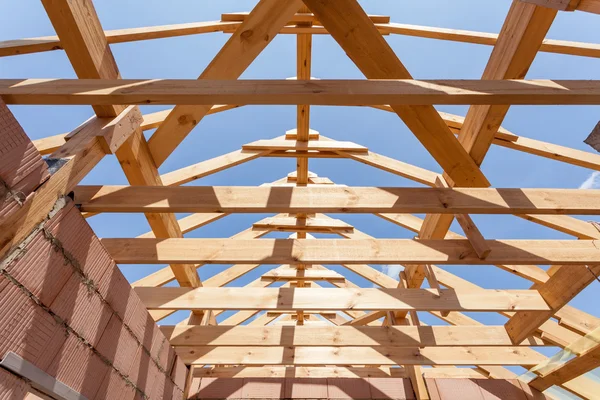 New residential construction home framing against a blue sky. Roofing construction. Wooden construction