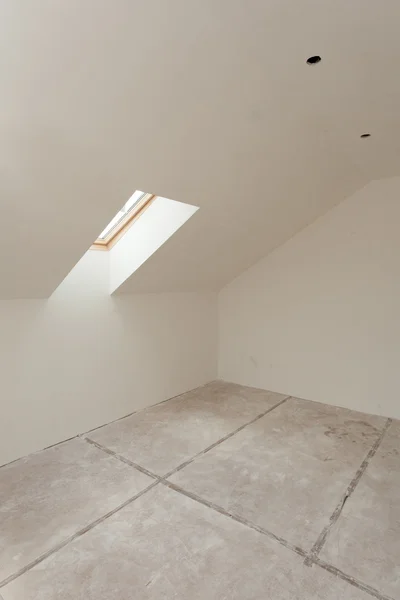 Attic room under construction with gypsum plaster boards and window