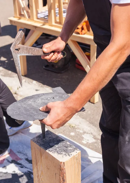 Worker produces roofing slate using a slate hammer