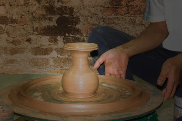 Pottery clay vase being formed and modeller hands