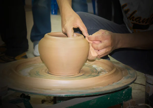 Pottery clay vase being formed and modeller hands