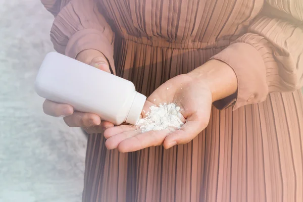 Women hand apply talcum powder