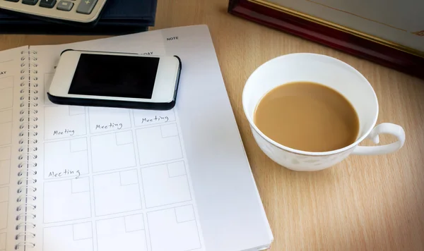 White cup of remain coffee in dim light office room with backgro