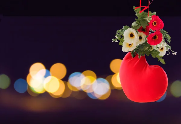 Sweet lovely background of red heart decorated with flower on bokeh light at night