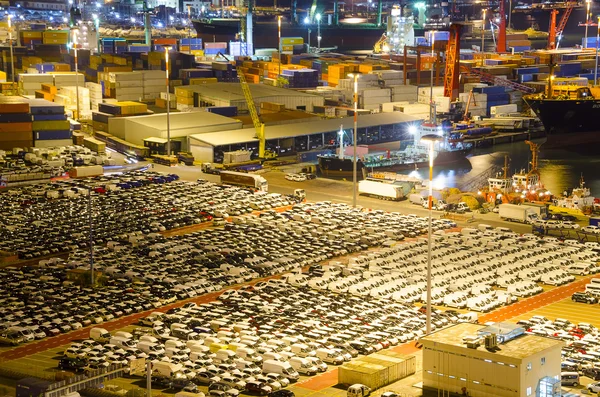 Cargo terminal in industrial port with containers and cars.
